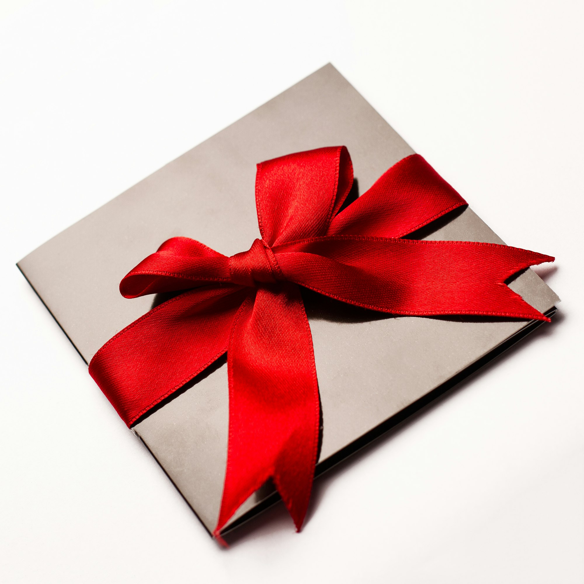 Black paper card with red textile ribbon isolated on white